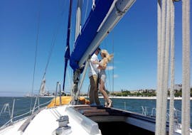 Imagen de una pareja en la cubierta durante el paseo romántico en barco al atardecer para dos por el río Tajo con Rent a Boat Lisbon.