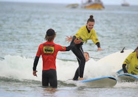 Student gives the teacher a high five during the beginners' surfing lessons (from 10 y.) on Praia da Arrifana with Arrifana Surf School.