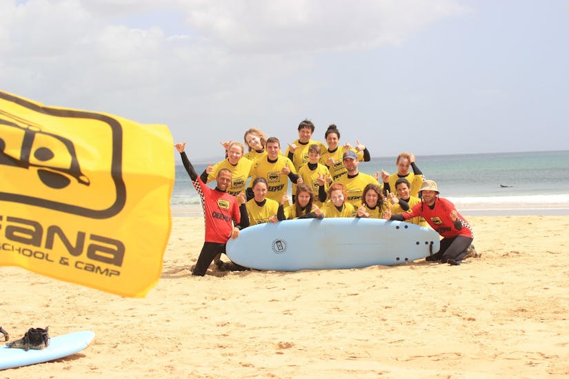Eine Gruppe glücklicher Surfer posiert für ein Foto, nachdem sie ihren von der Arrifana Surf School organisierten Surfkurs am Praia da Arrifana abgeschlossen haben.