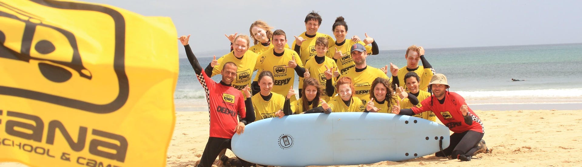 A group of surfers is posing for a photo to keep those special moments spent during the surfing lessons for kids & adults at Praia da Arrifana with their friendly surf instructor from Arrifana Surf School.