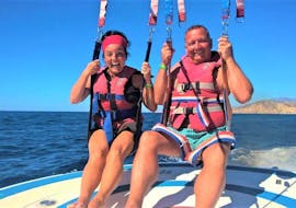 Two participants of the Parasailing organized by Carlos Water Sports Benidorm are smiling at the camera after landing from the sky above Benidorm.