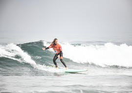 Een surfer surft op een golf tijdens hun surflessen (vanaf 13 j.) op het strand van Hendaye voor gevorderde surfers met École de Surf Hendaia.