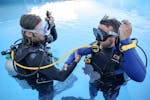 Ein Ausbilder führt mit einem Teilnehmer einen Sicherheitscheck durch, vor dem Open Water Diver Kurs in Rijeka mit Diving Center Marco Polo Rijeka.