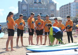 Les surfeurs sont sur la plage et écoutent les instructions de leur moniteur de surf pendant leur Cours de surf (dès 9 ans) sur la plage d'Hendaye pour Débutants avec École de Surf Hendaia.
