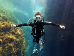 A diver swimming between rocks during Guided Dives from Port d'Andratx for Certified Divers with Balear Divers.