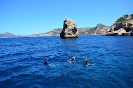 Drie personen in het water tijdens het snorkelen in Port d'Andratx aan de westkust van Mallorca met Balear Divers.