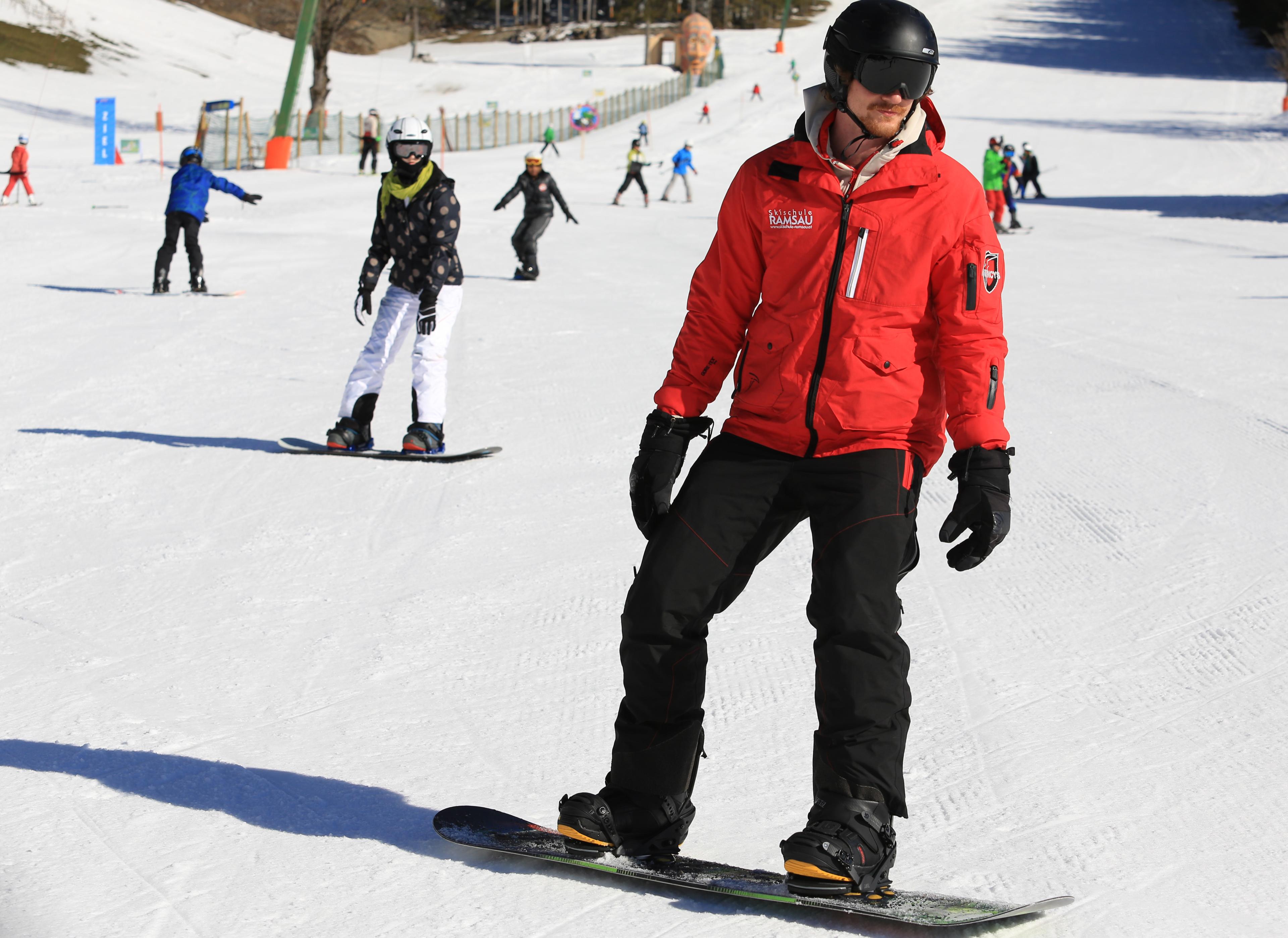 A student during private snowboarding lessons for adults of all levels with ski school Ramsau in Ramsau am Dachstein.