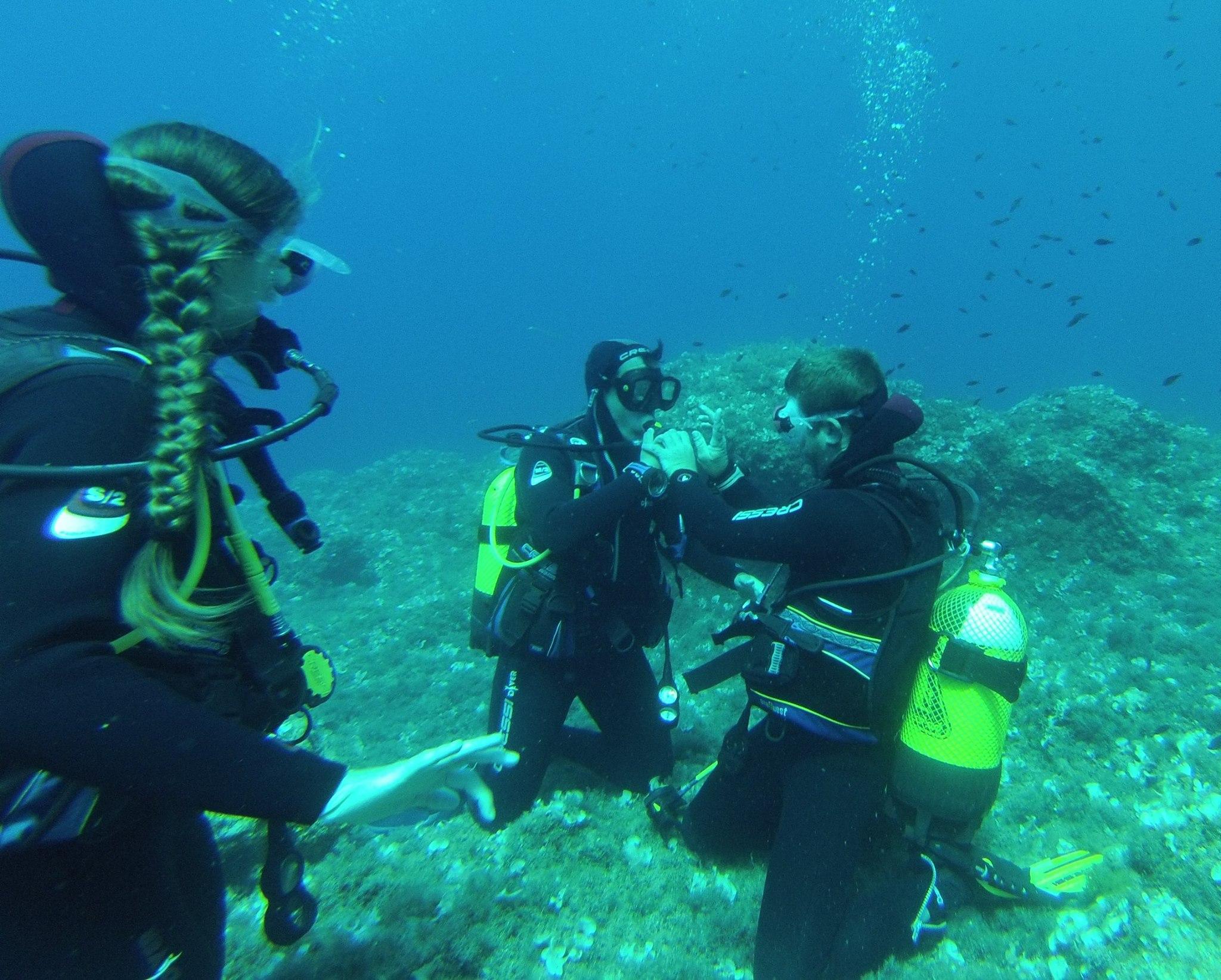 3 personas haciendo buceo de rescate durante el curso PADI Divemaster para Buceadores de Rescate Certificados con Balear Divers.