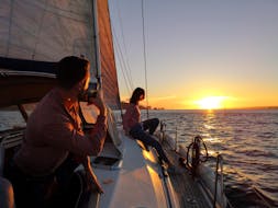 Persone che si godono la loro gita in barca a vela al tramonto sul Tago, incluso Christo Rei con Lisbona in barca