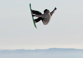 Ein Snowboarder springt während eines Freestyle Snowboarding Kurses für alle Könnerstufen mit Ausrüstung bei Boardstars Schladming.