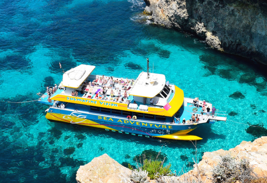 The catamaran approaches the cliffs of Gozo during the Boat Trip to Gozo & Comino including the Blue Lagoon with Sea Adventure Excursions Bugibba.