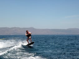 Una persona participa en la lección de wakeboard en Agia Marina con el centro de deportes acuáticos Cactus.