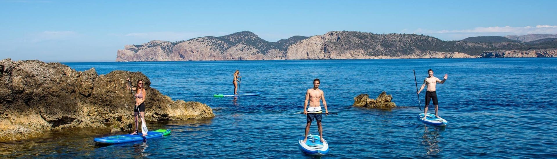 Group of participants stand-up paddling in the Malgrats Islands during a tour offered by ZOEA Mallorca.