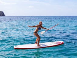 Una participante haciendo Stand-Up Paddling las Islas Malgrats durante un tour ofrecido por ZOEA Mallorca.