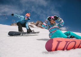 Zwei glückliche Kinder beim Snowboardkurs für Kinder mit Ausrüstung bei der Snowboardschule Boardstars Schladming. 