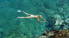 Une femme fait du snorkeling dans une mer cristalline durant une Excursion snorkeling à Chania avec Blue Adventures Diving Chania.