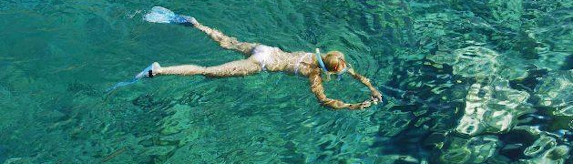Eine Frau beim Schnorcheln im kristallklaren Wasser mit Blue Adventures Diving Chania während des Schnorchelausflug mit dem Boot von Chania