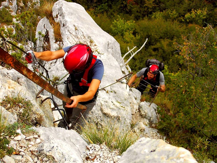 Zwei Teilnehmer am Klettersteig Via dell'Amicizia, der von Skyclimber organisiert wird, gehen in Richtung des Fotografen.