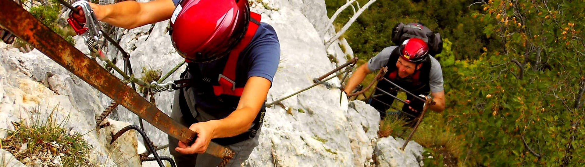 Zwei Teilnehmer am Klettersteig Via dell'Amicizia, der von Skyclimber organisiert wird, gehen in Richtung des Fotografen.