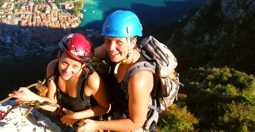Vía ferrata Vía dell'Amicizia en el lago de Garda con SKYclimber Tremosine Una chica se enfrenta a una vía ferrata con el guía de Skyclimber durante la vía ferrata Via dell'Amicizia.
