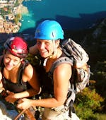 Eine junge Frau wagt sich während des Klettersteigs Via dell'Amicizia mit dem Guide von Skyclimber in luftige Höhen.