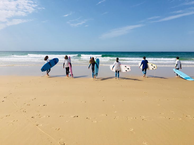 Un groupe d'élèves rejoigne la mer afin d'assister au Cours de Surf pour tous Niveaux dès 8 ans avec It's On Surf School.