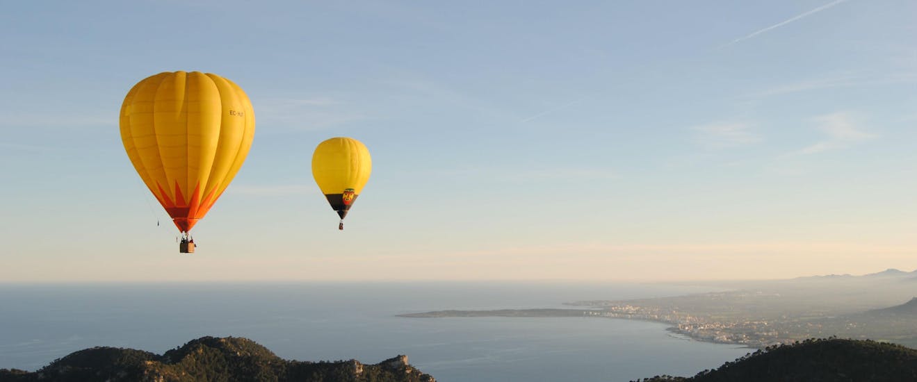 A group of participants hot air ballon flying over the sandy beaches of Mallorca in an activitiy offered by Illes Balears Ballooning.