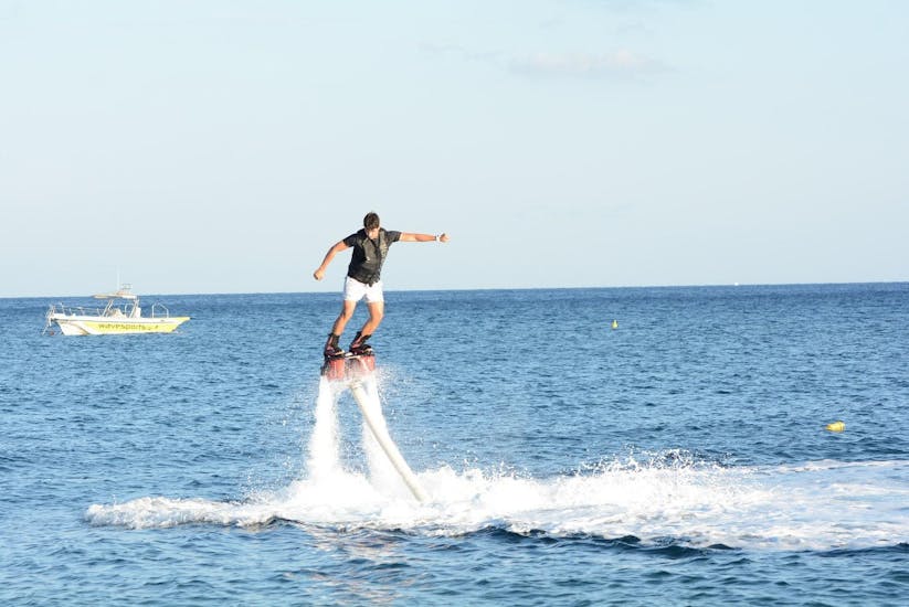 A young man is on the flyboard during the Flyboarding on Perissa or Perivolos Beach in Santorini with Wavesports Santorini.