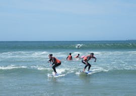 Two girls are learning how to surf during surfing lessons on Matosinhos Beach under the supervision of a certified surf instructor from Surfaventura.