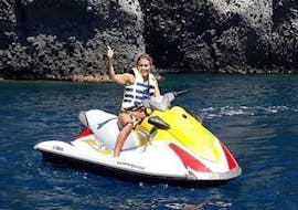 During the Jet Ski Tour "Extreme" from Agios Georgios organised by Crazy Sports, a woman is enjoying riding a jet ski along the spectacular volcanic cliffs of Santorini.
