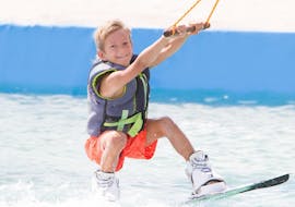Bajo la supervisión de un experimentado instructor de Crazy Sports, un niño pequeño disfruta del esquí acuático en Agios Georgios.