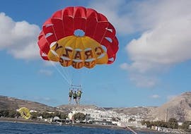 During the Parasailing close to Agios Georgios, a group of friends is enjoying the 360 degree views from a bird's-eye view whilst being towed and watched by professional staff from Crazy Sports.