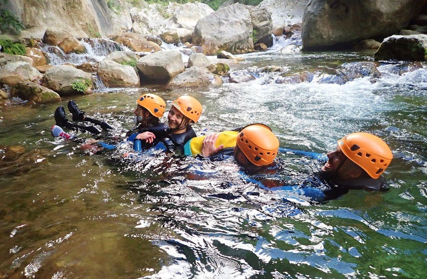 A group of friends are letting themselves be carried along by the current of the river during their River Trekking in Gorges du Loup for Young & Old with FunTrip.