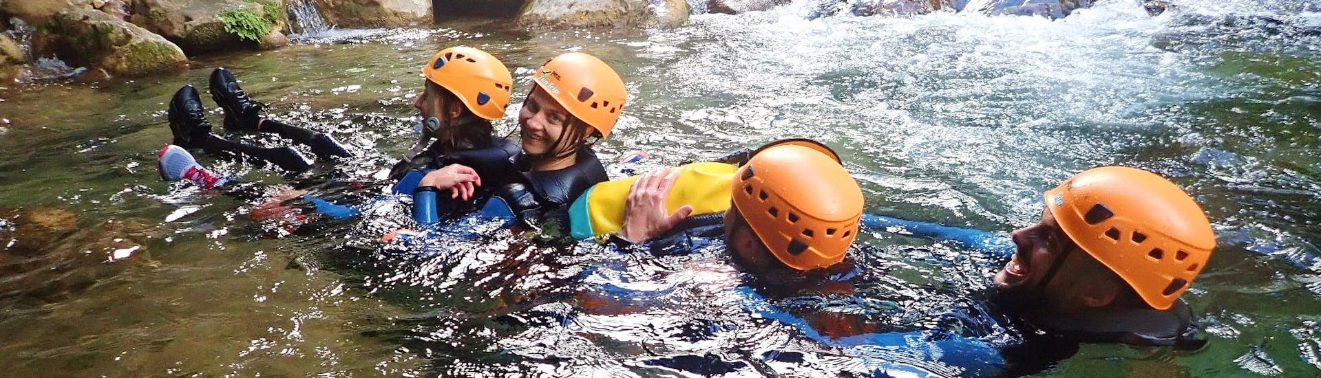 A group of friends are letting themselves be carried along by the current of the river during their River Trekking in Gorges du Loup for Young & Old with FunTrip.