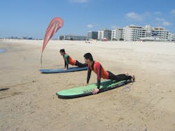 Durante el curso privado de surf en la playa Matosinhos, un chico se beneficia de la completa atención de su instructor de surf de Surfaventura mientras aprende la teoría del surf.