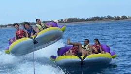 Un groupe d'amis s'amuse à faire un tour palpitant sur une bouée gonflable remorquée par un bateau à moteur de Crazy Sports.