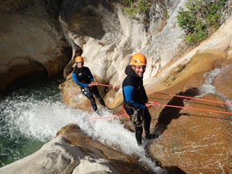 Two friends are abseiling down the canyon during their Canyoning in the Gours du Ray Canyon - Aquatic tour with FunTrip.
