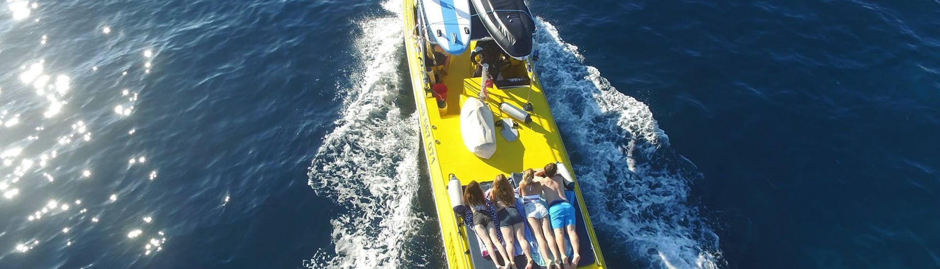 Persone che si divertono sull'imbarcazione durante un giro in barca intorno alla grotta e alla spiaggia di Ibiza con snorkeling con Take Off Ibiza.