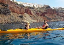 During a sea kayak tour, a couple is paddling with a professional kayak guide from Santorini Sea Kayak around the magical city of Santorini.