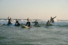 Una participante hace su primera experiencia de surf cunto a Linha de Onda Surfing School durante su clase de surf con traslado hasta Matosinhos.
