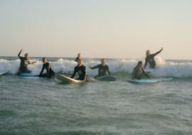 Eine Kursteilnehmerin macht gemeinsam mit Linha de Onda Surfing School ihre ersten Erfahrungen im Surfen während dem Surfkurs mit Transfer nach Matosinhos.