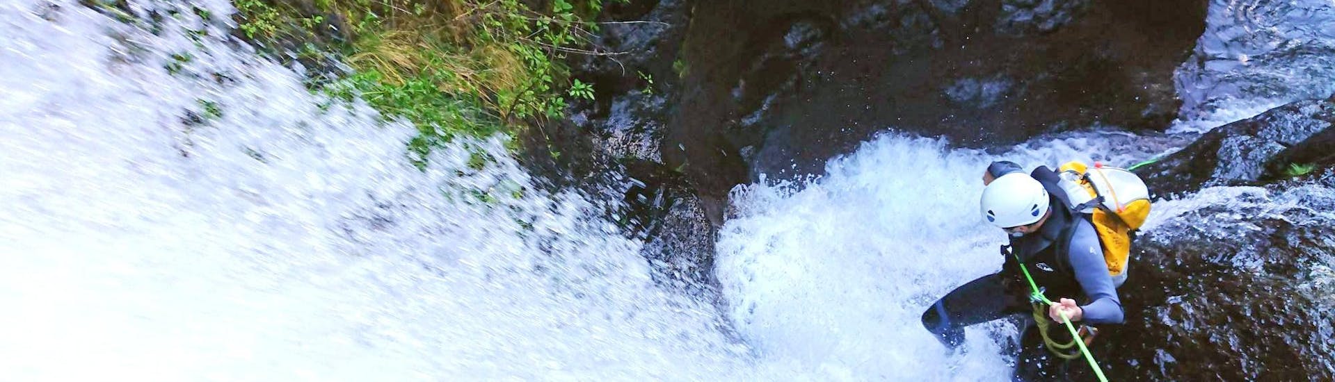 During the Canyoning "Intermediate" - Madeira with Epic Madeira, a participant is bravely roping down over a thunderous waterfall.