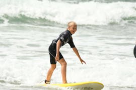 Una ragazza sta prendendo lezioni di surf sulla spiaggia di Marbella con la scuola Eco Surf di Biarritz.