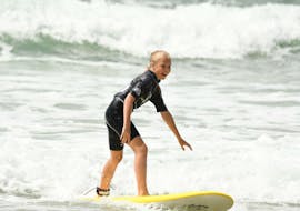 A girl is having Surfing Lessons on the Marbella Beach with the Eco surf school in Biarritz.