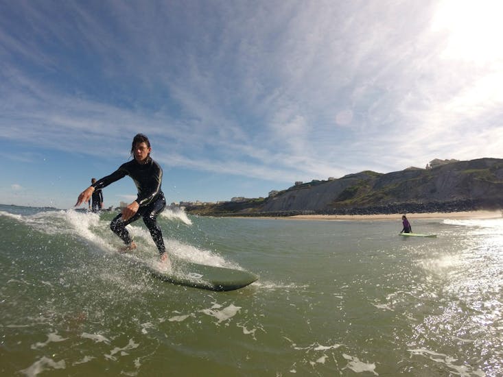 Un homme surfe sur une vague pendant un cours de surf sur la Plage de Marbella avec l'école Eco surf school à Biarritz.