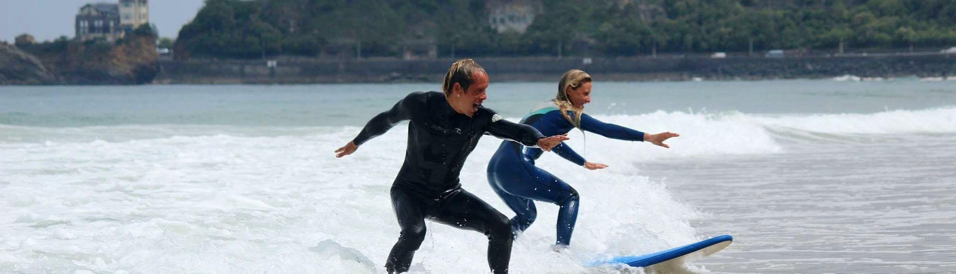 A man is having private surfing lessons on the Marbella Beach with her instructor of the eco surf school in Biarritz.