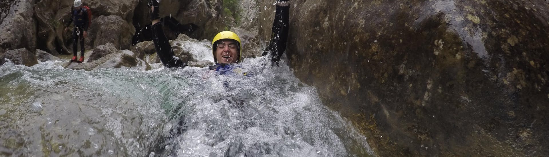 A young man is abseiling down a waterfall while canyoning in the Cetina River with Active 365.