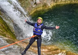 A young man is abseiling down a waterfall while canyoning in the Cetina River with Active 365.