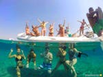 Photo of people on the boat and in the sea partying during Private Party Boat Trip in Hvar for Bachelor & Bacherolette with Hvar Boats.