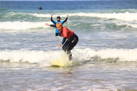 Un jeune surfeur prenant sa première vague lors de ses cours de surf pour Débutants avec Algarve Adventure.